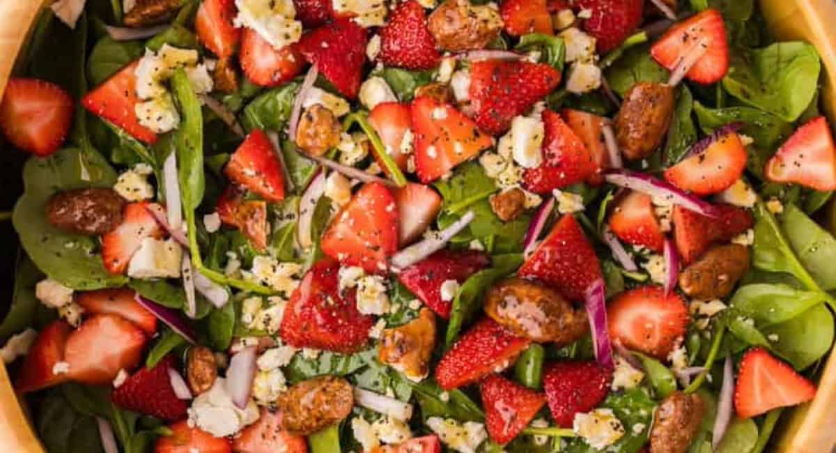 Overhead image of strawberry feta spinach salad with garnish. 