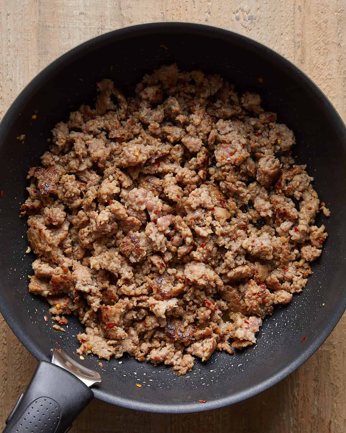Cooked Italian sausage crumbled and browned in a skillet for baked stuffed shells.
