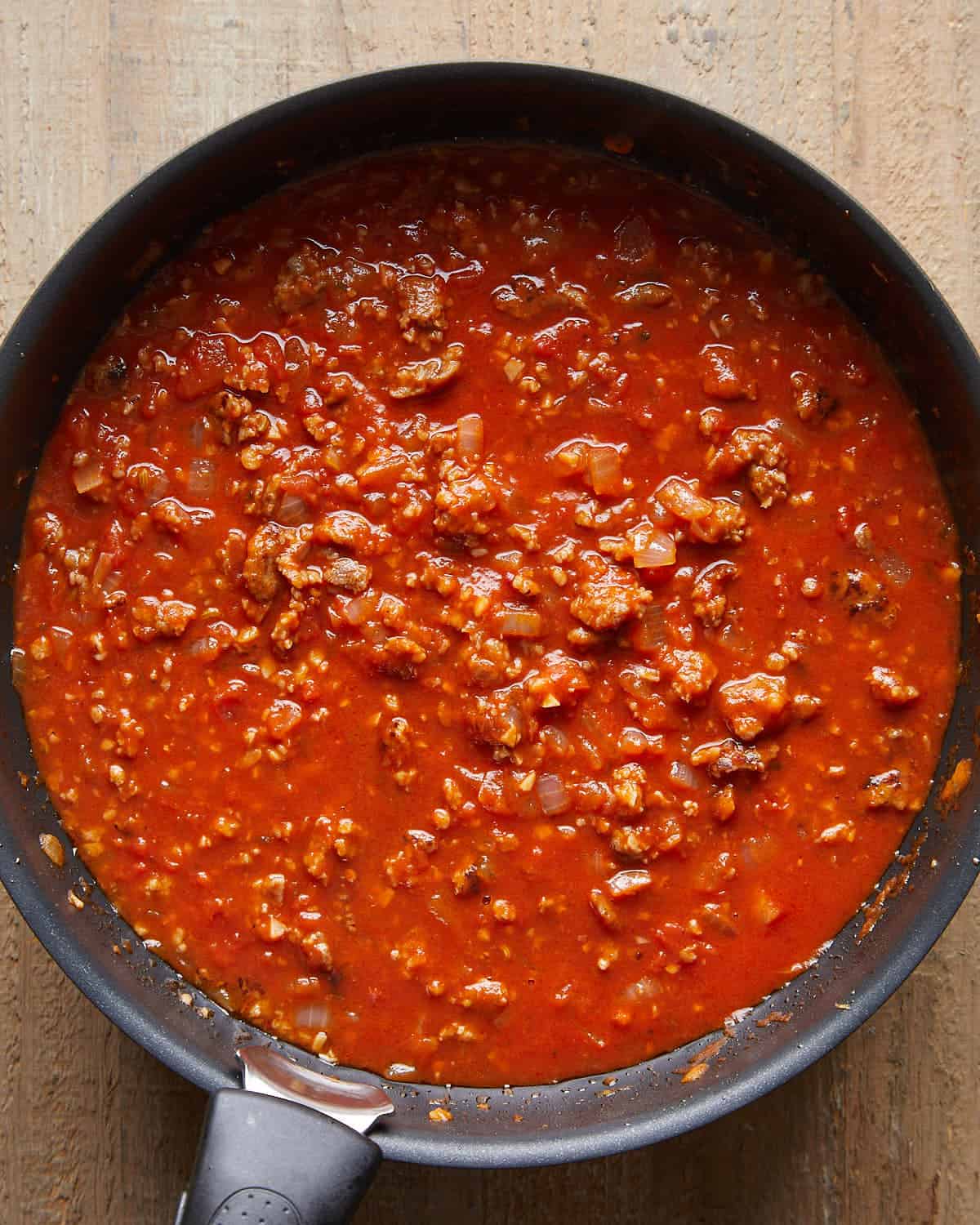 Overhead view of marinara sauce mixture for baked stuffed shells, smooth tomato sauce ready to layer in the dish.
