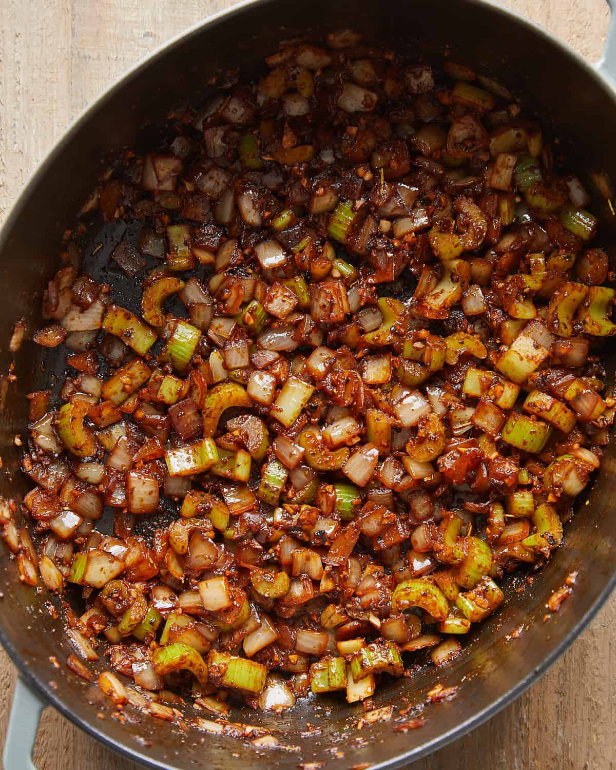 Overhead view of celery and onion sautéed in a pot for Dutch Oven Pot Roast.