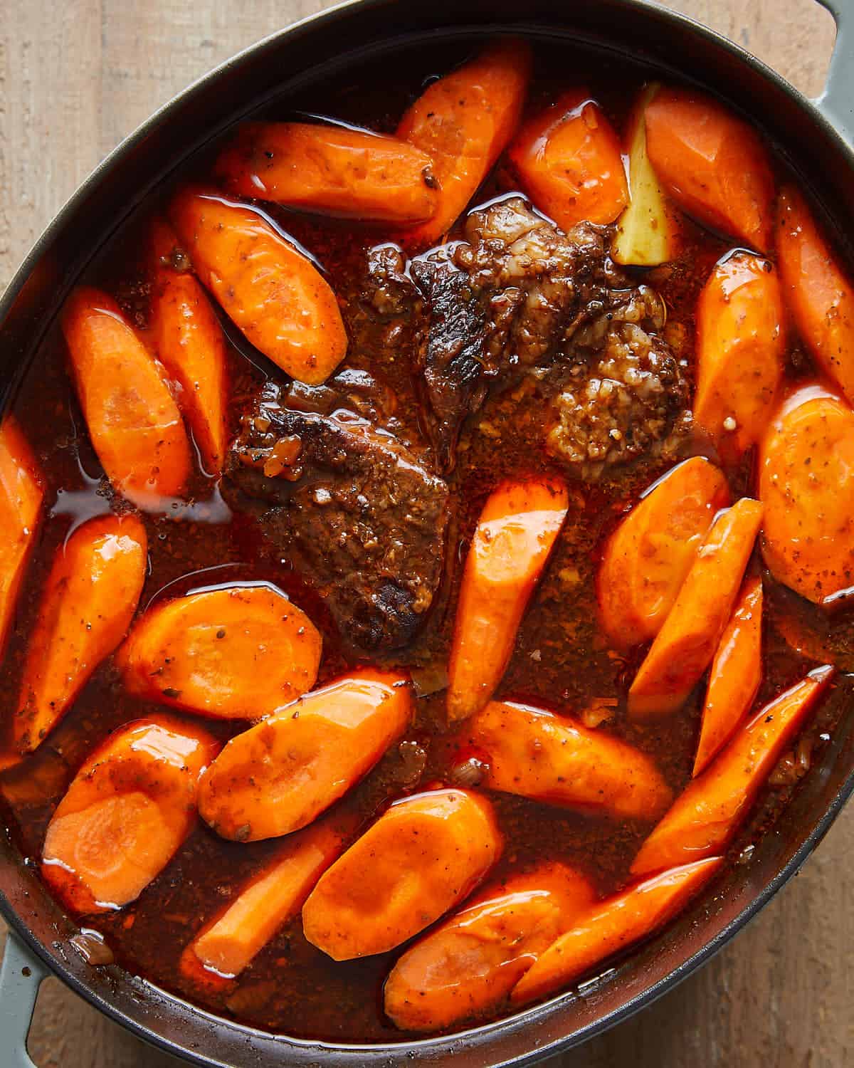 Overhead view of potatoes and carrots added to the pot for Dutch Oven Pot Roast.