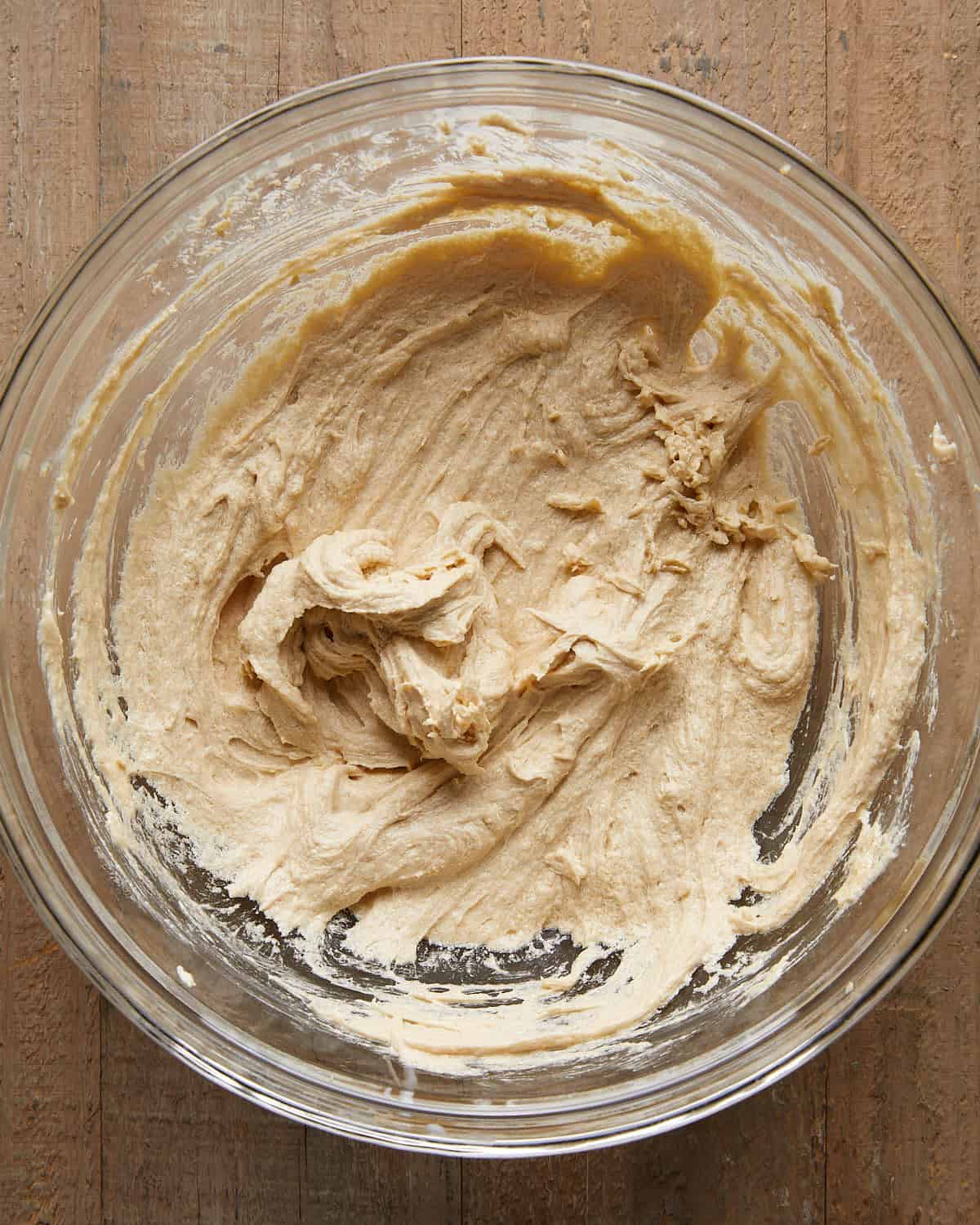 Overhead image of water, leaveners, and salt being added to the dough for no chill chocolate chip cookies, an essential step for proper rise, texture, and flavor.