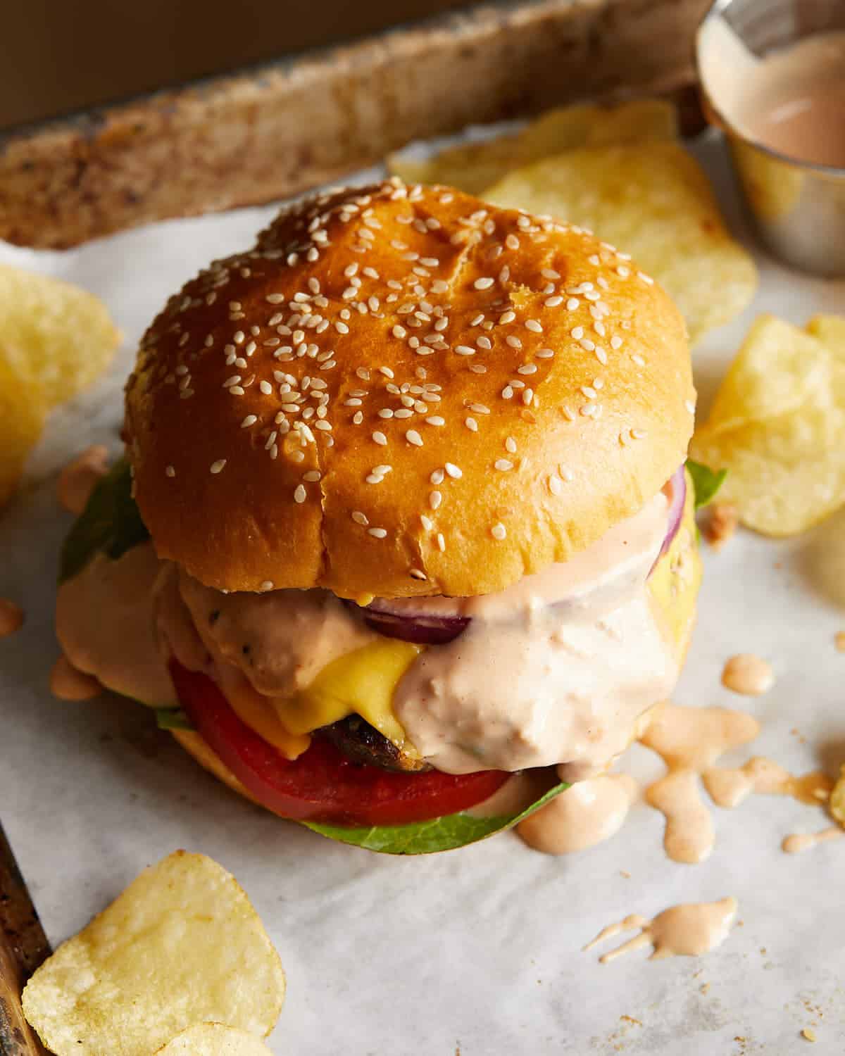 Close-up of a toasted burger bun spread with burger sauce.