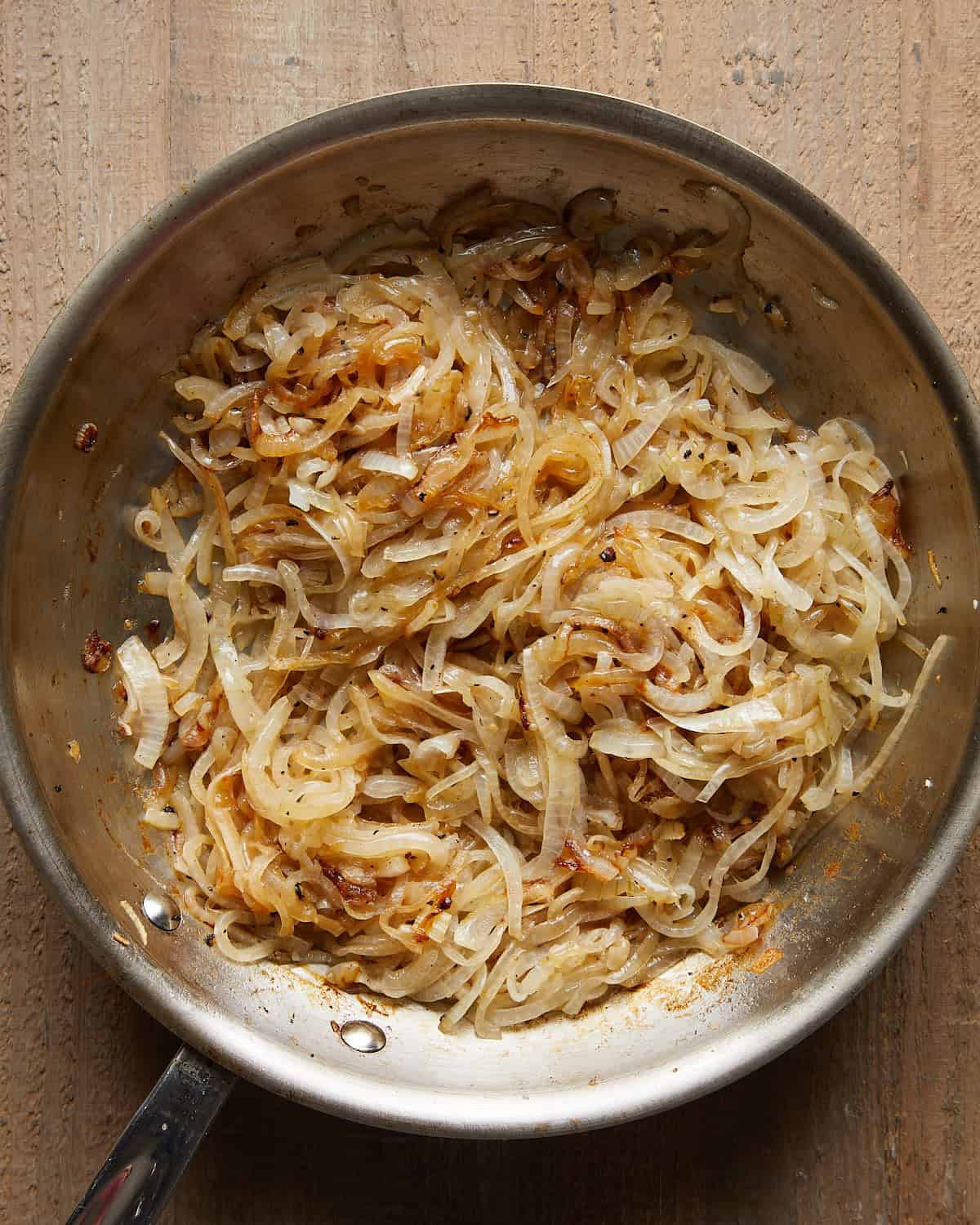 Thinly sliced onions beginning to soften in a pan with butter.