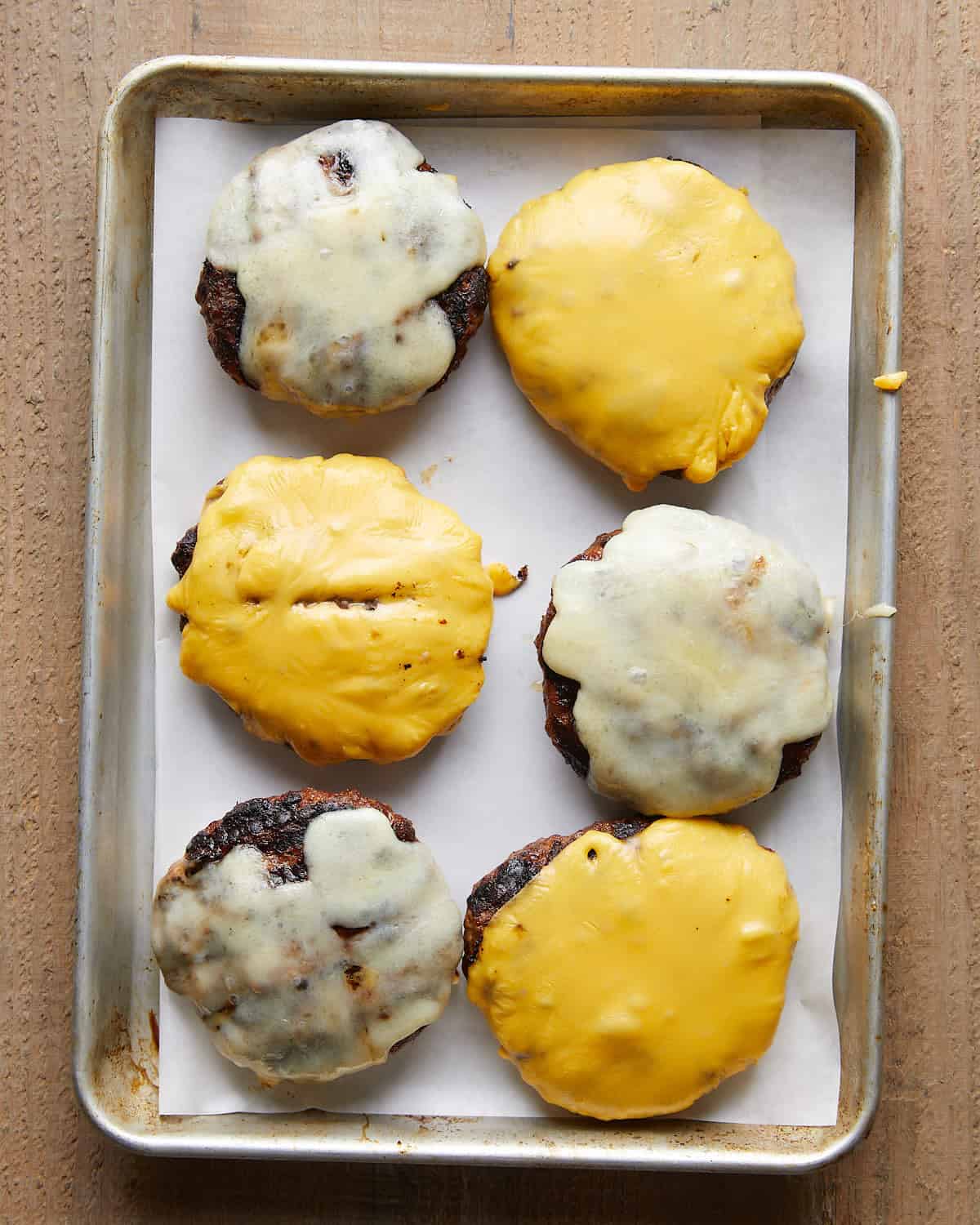 Grilled burger patties topped with melted cheese.