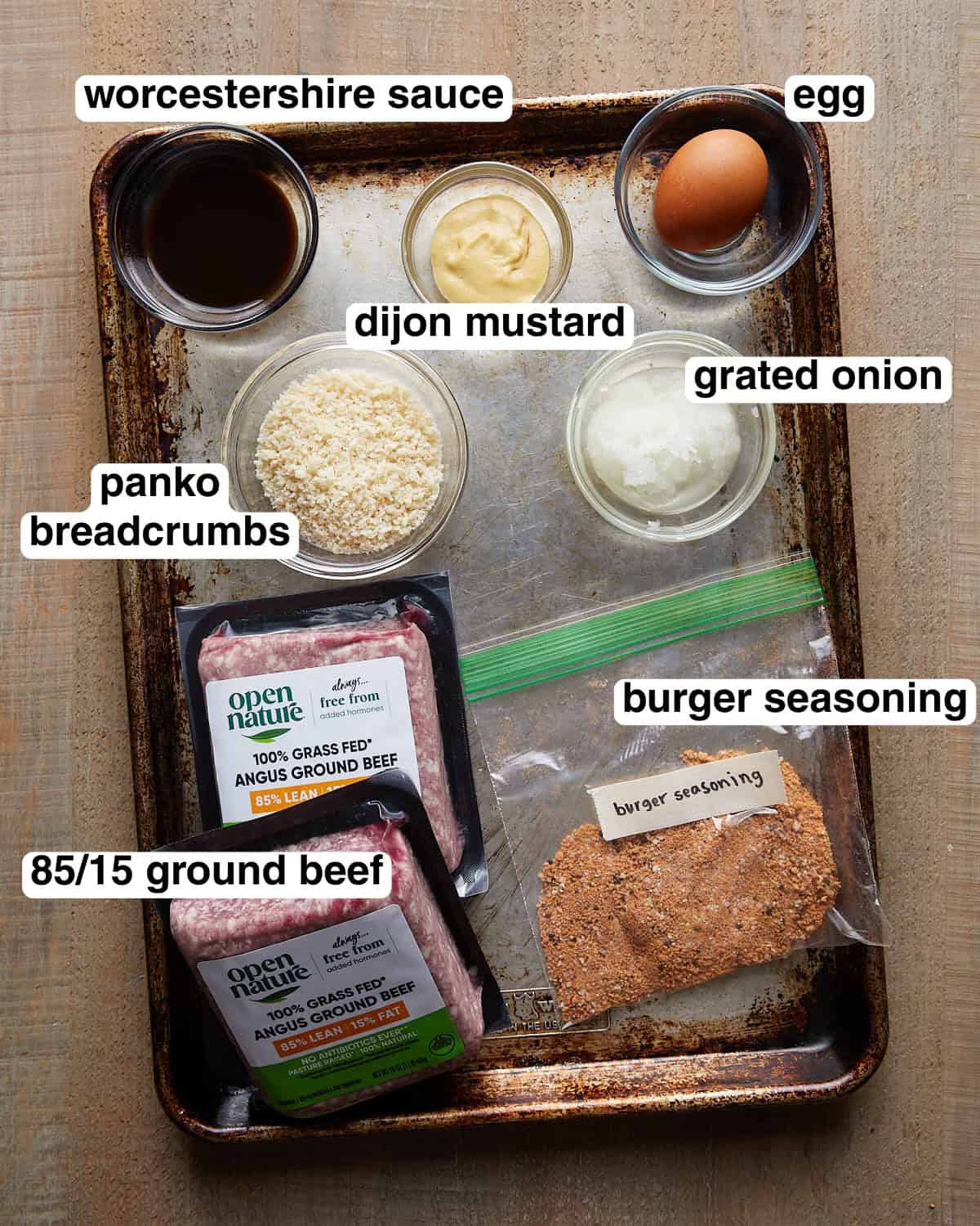 Labeled ingredients for grilled burger patties, including ground beef, burger seasoning, panko breadcrumbs, Dijon mustard, grated onion, and sauce.