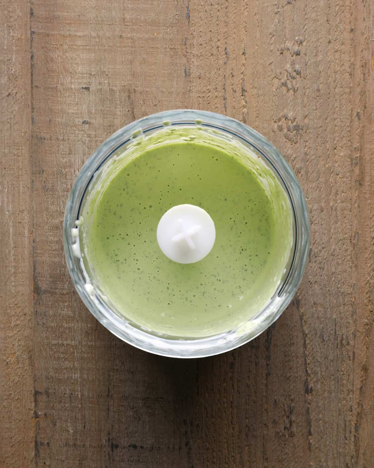 Creamy basil aioli in a food processor after blending.
