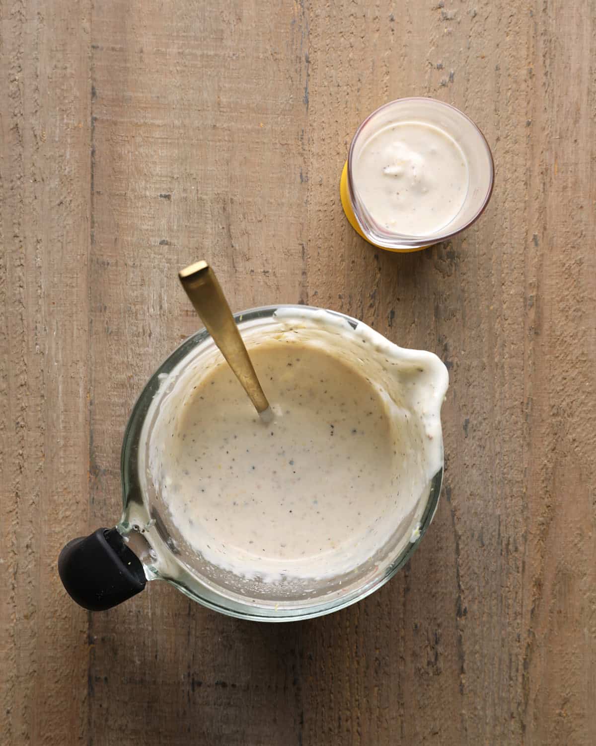 Caesar marinade ingredients mixed in a small bowl with a spoon.