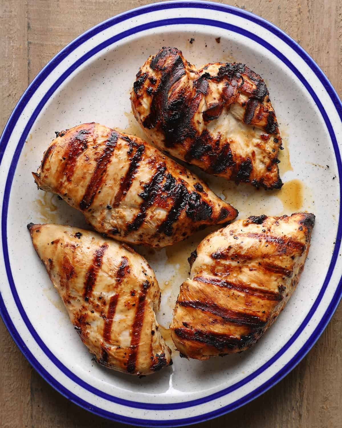 Grilled Caesar chicken breasts on a serving plate.