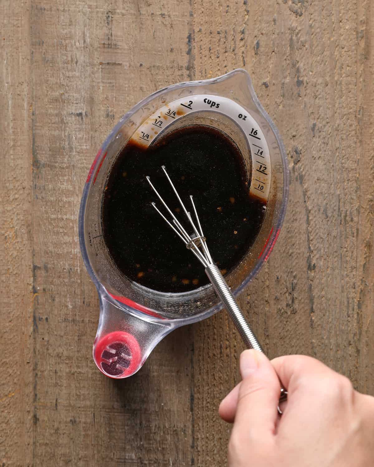 Mongolian beef sauce being whisked together in a measuring cup.