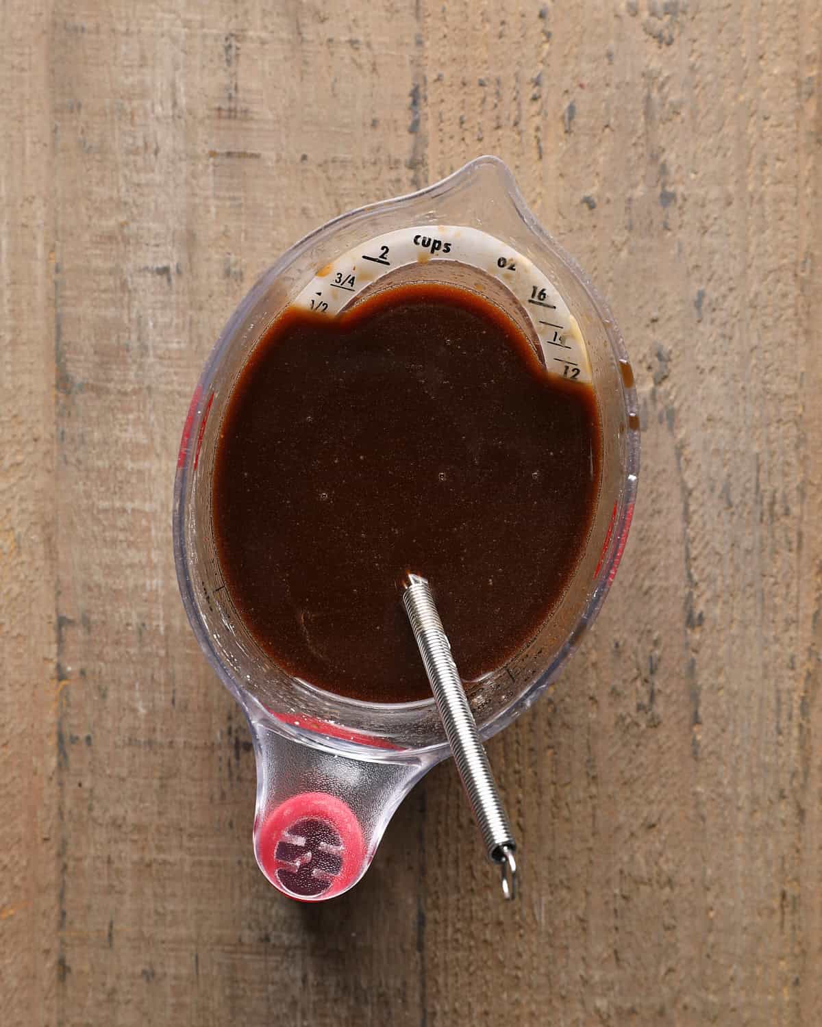Finished Mongolian beef sauce in a measuring cup before adding it to the pan.