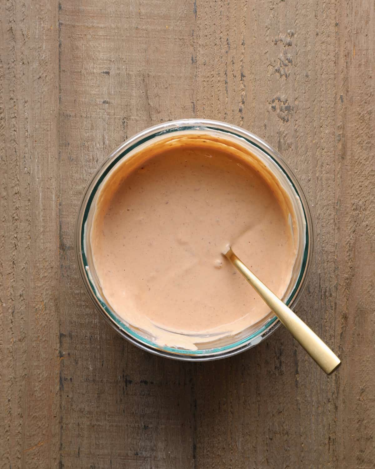 Chipotle crema in a glass bowl with a spoon.
