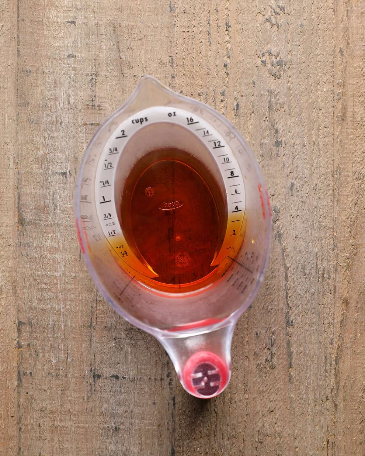 Reduced apple cider measured to 1/2 cup in a liquid measuring cup.