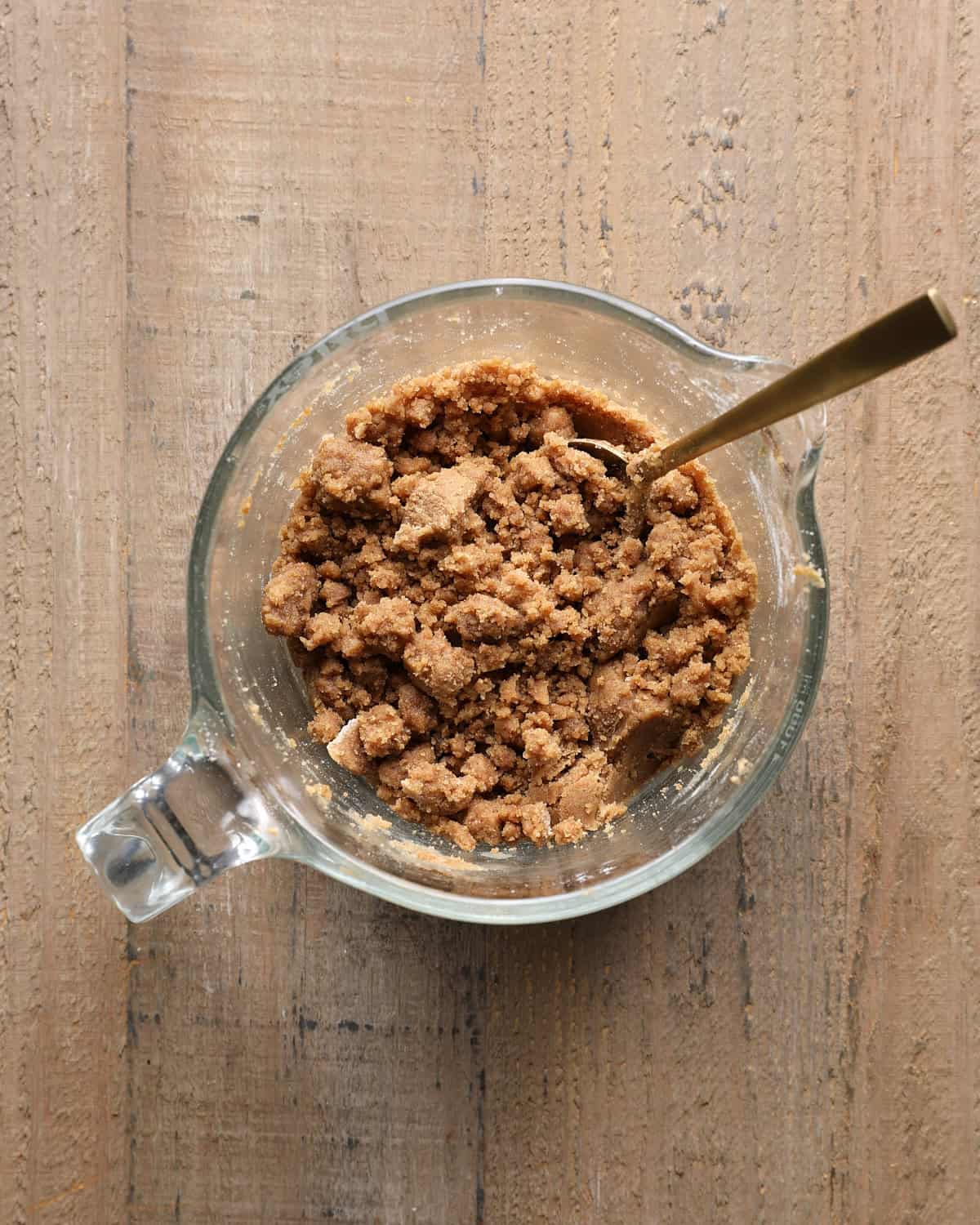 Cinnamon crumb topping with large and small crumbs in a measuring cup.