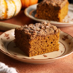 A slice of pumpkin coffee cake with a thick dark brown sugar crumb topping.