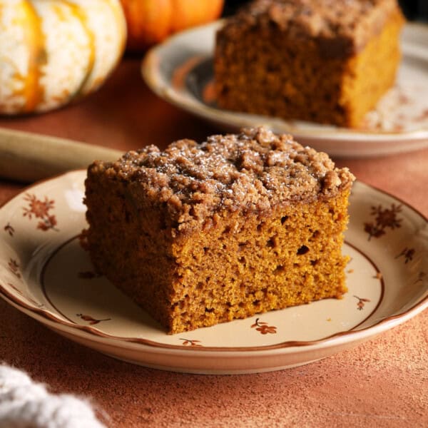 A slice of pumpkin coffee cake with a thick dark brown sugar crumb topping.