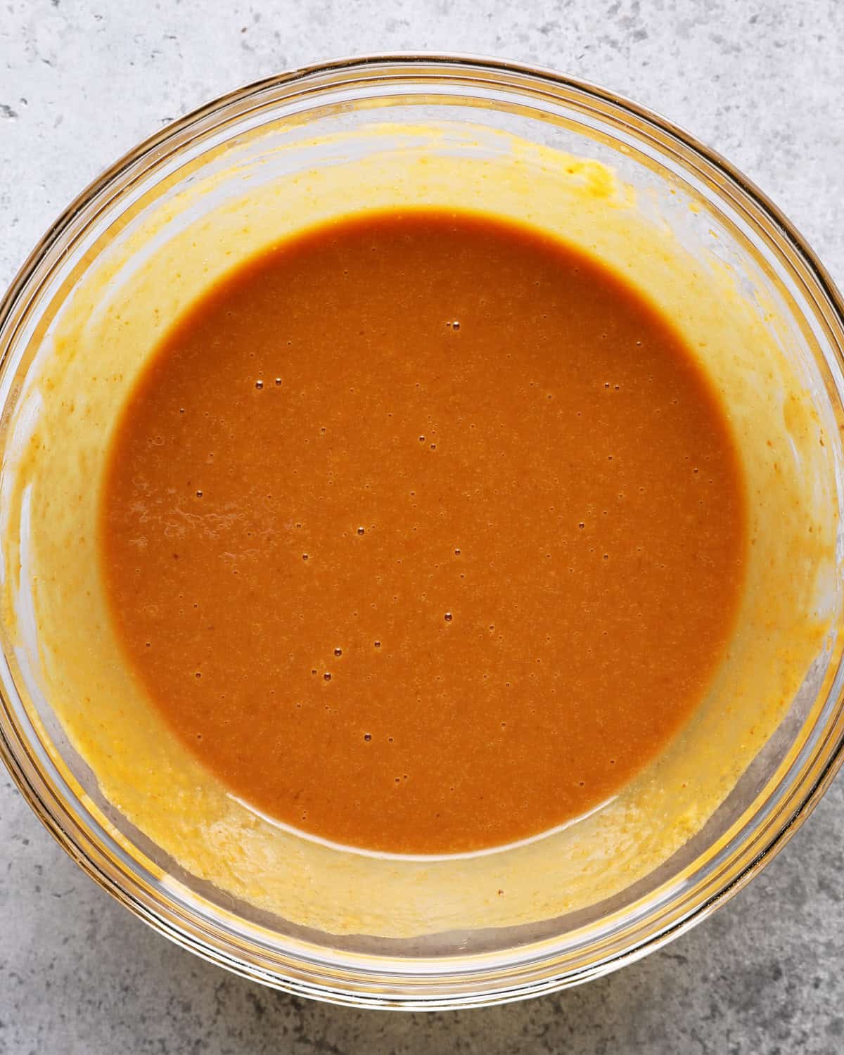Smooth pumpkin mixture whisked with dark brown sugar, eggs, oil, sour cream, and vanilla.