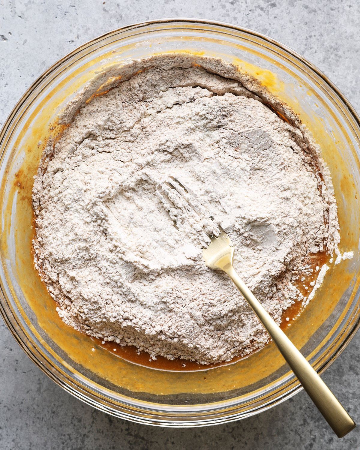 Flour and dry ingredients added on top of the pumpkin mixture before folding.